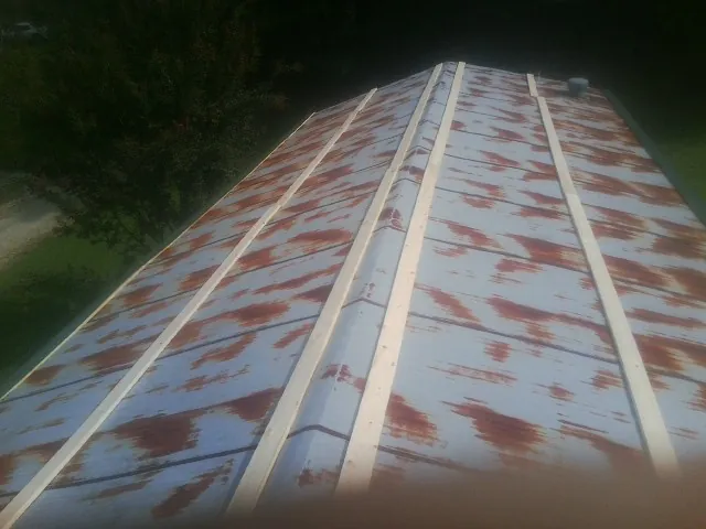 Rusted metal roof panels with new wood purlins before replacement — Storm Damage Roof Repair in Pineville by Roofing Brothers